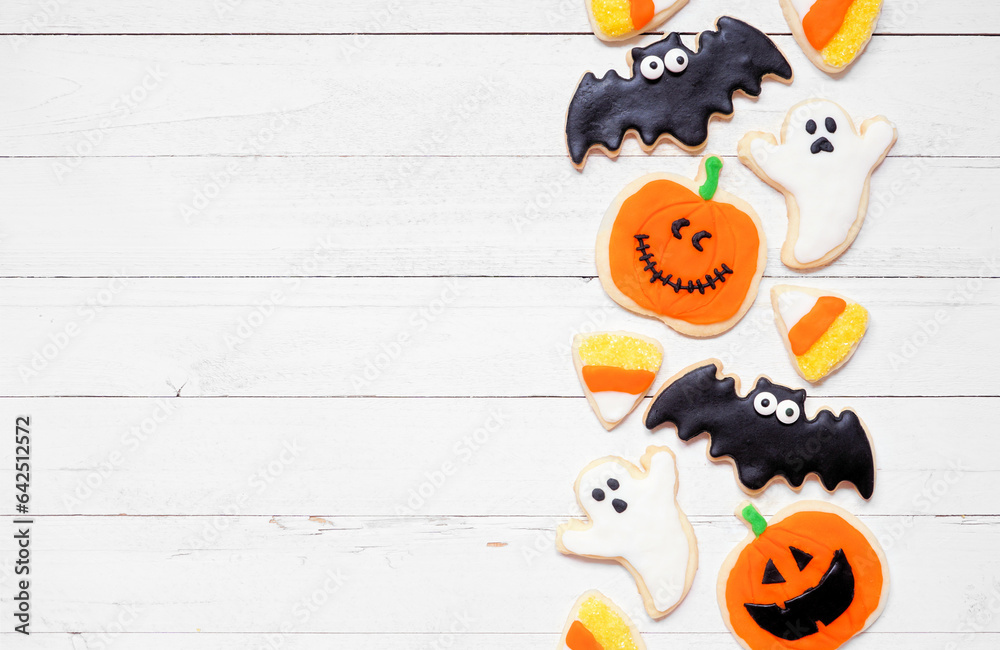 Poster halloween cookie side border. overhead view on a white wood background with copy space. ghosts, bats