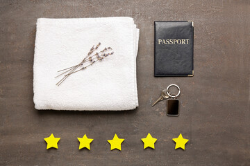 Five stars with towel, key from hotel room and passport on dark background. Customer experience...