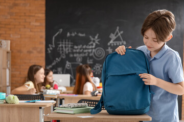 Little boy with backpack in classroom