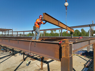 worker on the steel beams handling a beam