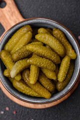 Delicious small pickled cucumbers gherkins with onions, mustard, salt and spices