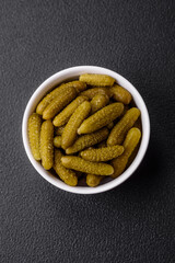 Delicious small pickled cucumbers gherkins with onions, mustard, salt and spices