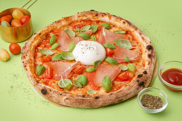 Tasty pizza with Burrata cheese on green background