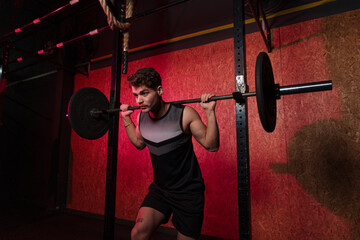 Man focused performing barbell squats