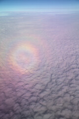 Travel background with circular glory around the shadow of the plane of the clouds below
