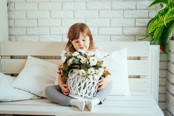 child with a bouquet in a basket gift to mom for Mother's Day