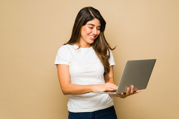 Attractive woman using the laptop and a mockup t-shirt