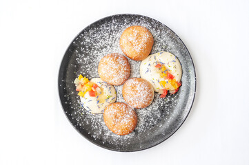 Pancakes syrniki with fruit, vanilla mousse and powdered sugar
