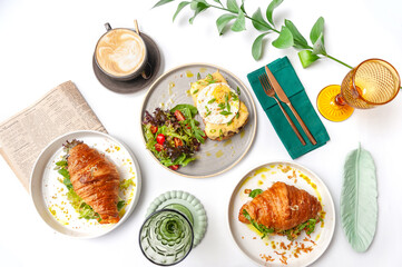 Set of breakfast dishes: croissants, toast, scrambled eggs, salad, bruschetta