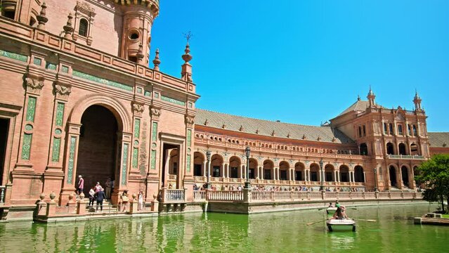 Tourists sailing on the boats in Plaza de Espa&ntilde;a on a beautiful day in Seville. People in the lake exploring Historical most famous landmark Plaza Espa&ntilde;a, Sevilla