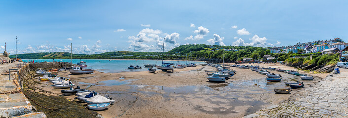 A panorama view from the harbour wall at low tide in the town of New Quay, Wales in summertime