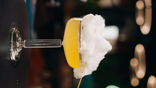 vertical video fresh tasty alcoholic cocktail with cotton candy rotates on the bar counter in a bar or restaurant