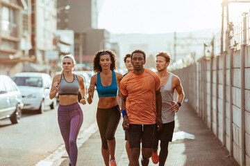 Diverse group of young people running together in the city
