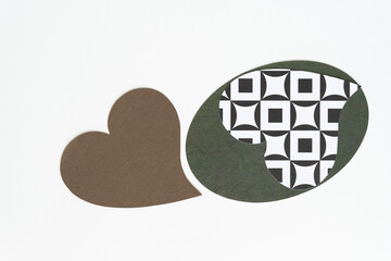 brown paper heart and oval shape with a hard to see square-in-circle heart shape on white