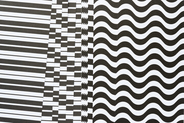 straight and wavy black and white paper with some paper irregularly spaced