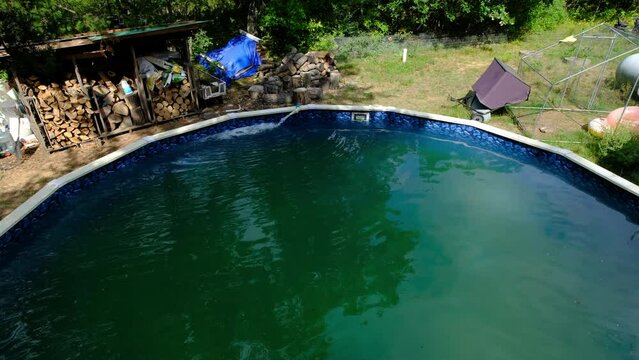 Wide angle of green water in outdoor pool full of algae after left without treatment for longer period of time.