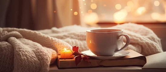 Foto auf Acrylglas Cozy home decor with vintage bokeh including a sweater tea cotton book and candle © vxnaghiyev