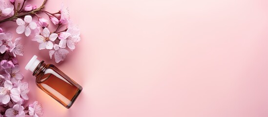 Flat lay with essential oil flowers and copy space on pink background representing beauty spa and health