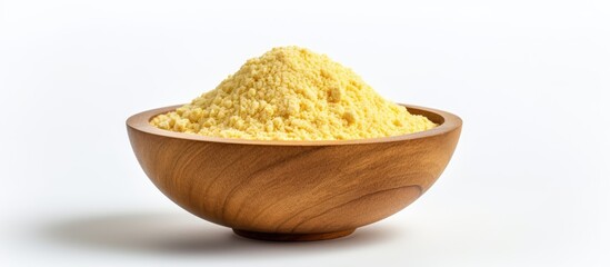 Nutritional yeast in white bowl on wooden backdrop