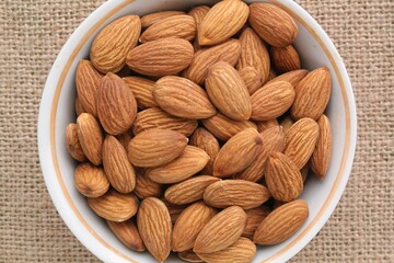 Almond on eco canvas napkin background. Healthy eating, nutrition, vegan concept, vegetarian diet. Protein organic raw food. Dry snack. National nut day. Copy space for text