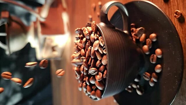 Coffee bean, coffee beans falling in super slow motian into a black cup on rustic surface, vertical video.