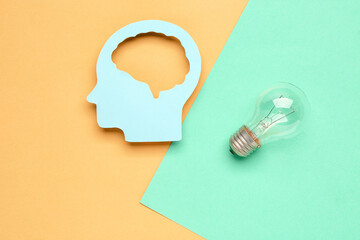 Paper human head with light bulb on color background. Logic concept