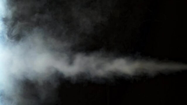Smoke, jet of white smoke expelled from a point with black background, natural light, 4k.