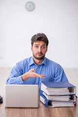 Fototapeta premium Young male employee working in the office
