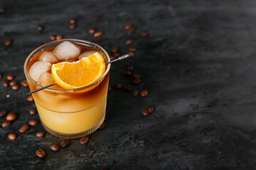 Glass of cold orange espresso on black background
