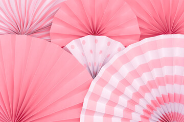 Folded round pink and white paper fan background.