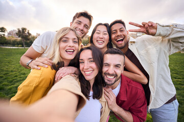 Group of young cheerful multi-ethnic friends taking selfie with mobile phone outdoor. Happy people...