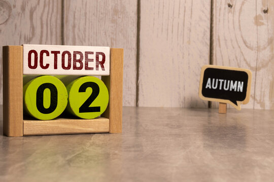 October 2 on a wooden calendar on a table or shelf.One day of the autumn month.Calendar for October.