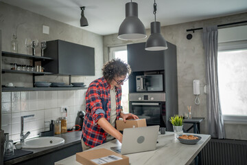 one man checking box of received package or product at home