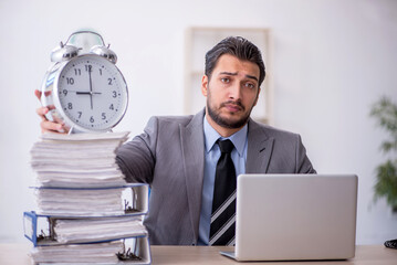 Young male employee in time management concept