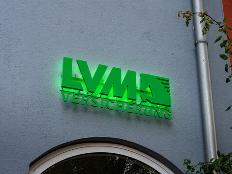 PLAU AM SEE, GERMANY - 3. October 2022: LVM Versicherung (insurance) logo sign illuminated with green color on a building wall. The company is offering financial services.