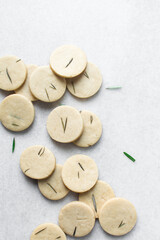 Top view of cut out rosemary sugar cookies, rosemary cookie on a white background, process of making rosemary sugar cookies