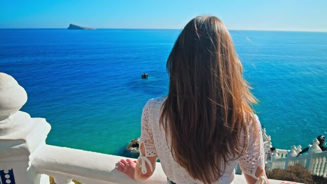 A girl looking at BALCON DEL MEDITERRANEO a lookout deck white stone balustrades. Tourist enjoying Balcony to the Mediterranean offering coastline view
