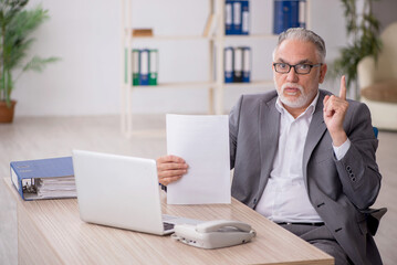 Old male employee working in the office