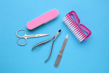 Set of pedicure tools on light blue background, flat lay