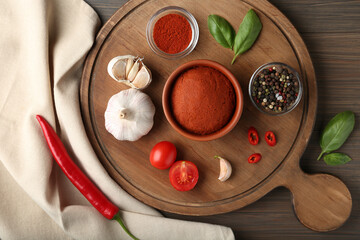 Red curry paste and ingredients on wooden table, flat lay