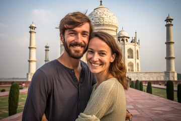 Couple in their 30s smiling in front of the Taj Mahal in Agra India