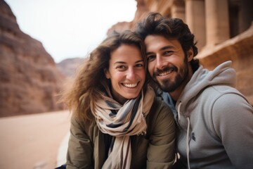 Fototapeta premium Couple in their 30s smiling at the Petra in Maan Jordan