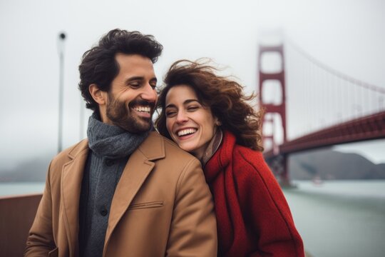 Couple in their 30s smiling at the Golden Gate Bridge in San Francisco USA