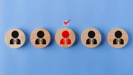 Wooden figures of people on a blue background with a red check mark. Online recruitment application specialist search service concept