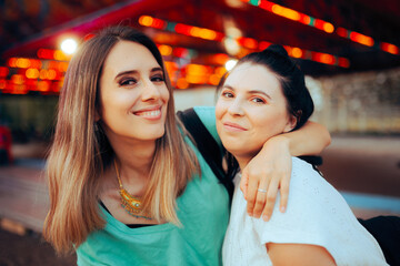 Cheerful Girls Having Fun Together in an Amusement Park. Women being best friends hanging out together 
