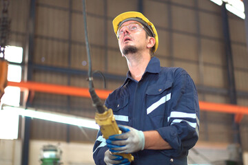 Factory worker - technician controlling a heavy crane in factory close up at his hands holing a crane controller.