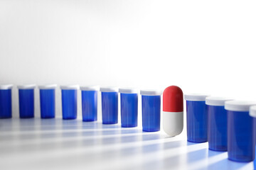 Close-up of colorful pill and container bottles on white background