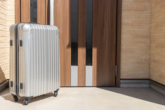 玄関前に置いたスーツケース - Powered by Adobe