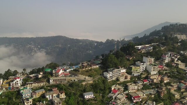 Aerial shot of almora city, situated in mountains covered with clouds. 