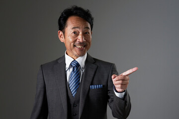 右側を指差す中年のビジネスマン　黒背景